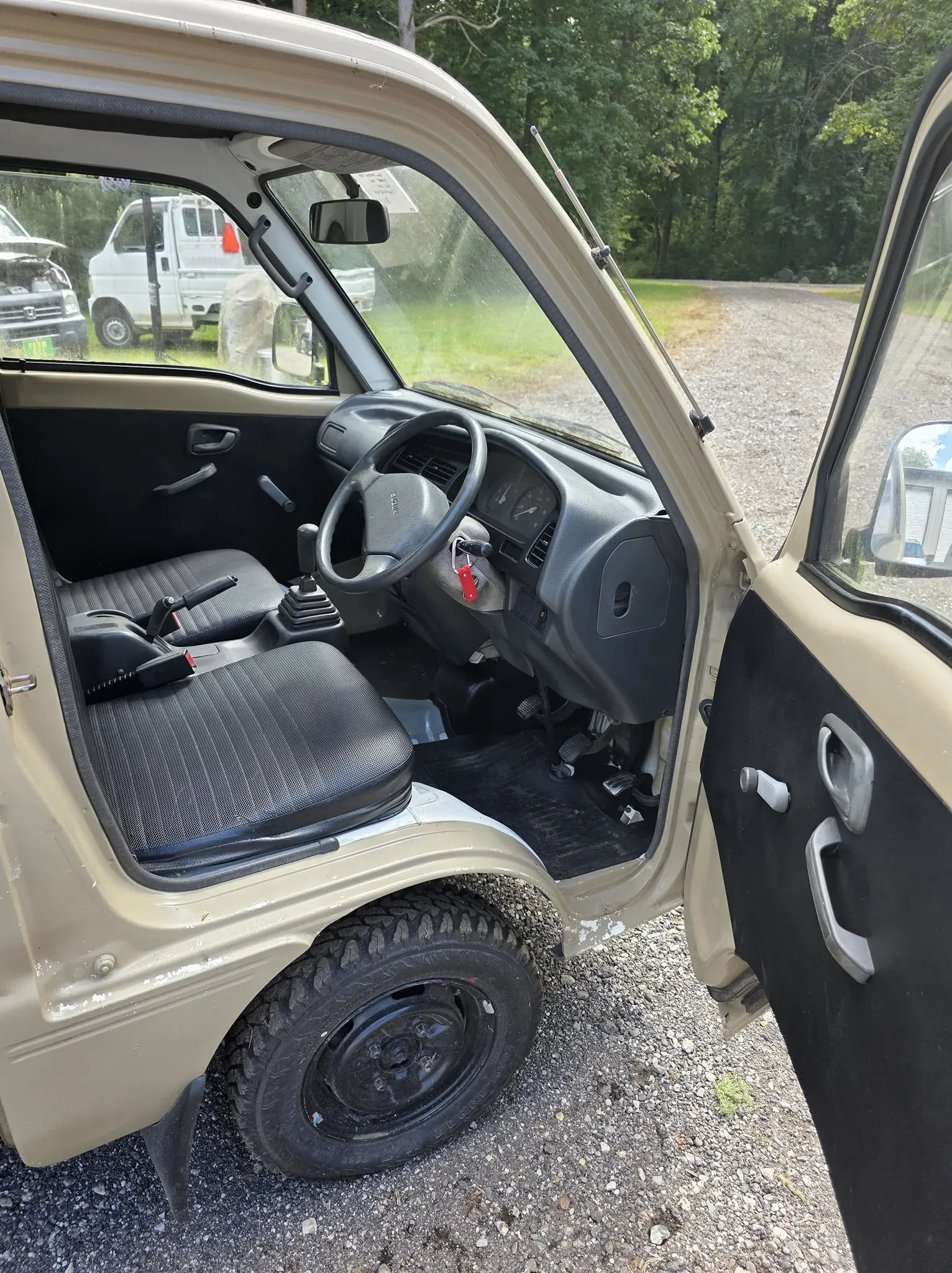 Mini truck cab interior with bench seat and manual transmission